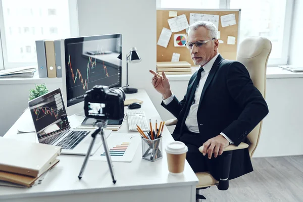 Hombre mayor en traje de negocios elegante usando tecnologías modernas mientras hace video en redes sociales — Foto de Stock