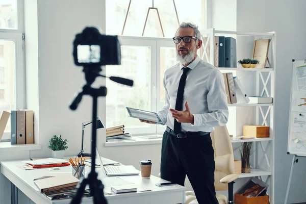 Sebevědomý dospělý muž v elegantní košili a kravatu říká něco, zatímco sociální média videa — Stock fotografie