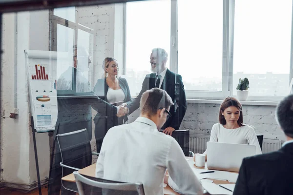 Empresarios Seguros Estrechándose Mano Mientras Trabajan Junto Con Equipo Sala — Foto de Stock