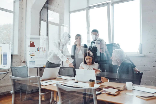 取締役会室でスタッフミーティングを行いながら 現代の技術を活用した営業を分析する自動機のビジネスチーム — ストック写真