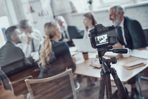 Modern business team discussing strategy while filming staff meeting in the board room