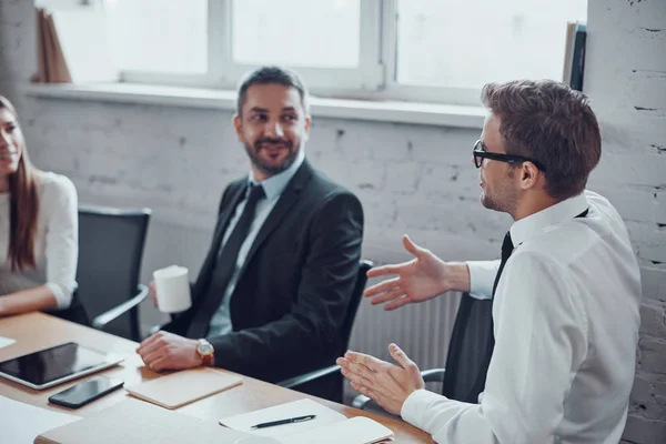 Felices Hombres Negocios Discutiendo Algo Sonriendo Mientras Trabajan Juntos Oficina —  Fotos de Stock