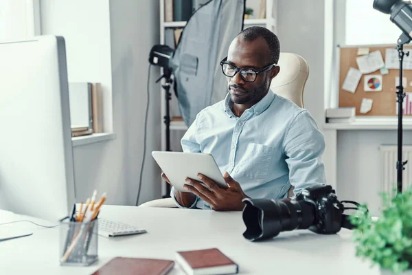 在现代办公室工作时使用数码平板电脑的英俊的非洲年轻人 — 图库照片