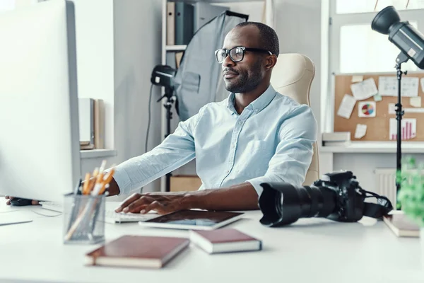 現代のオフィスで働いている間 コンピュータを使用してハンサムな若いアフリカ人男性 — ストック写真
