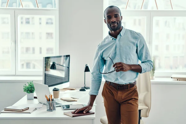 Feliz Joven Africano Con Camisa Mirando Cámara Sonriendo Mientras Trabaja —  Fotos de Stock