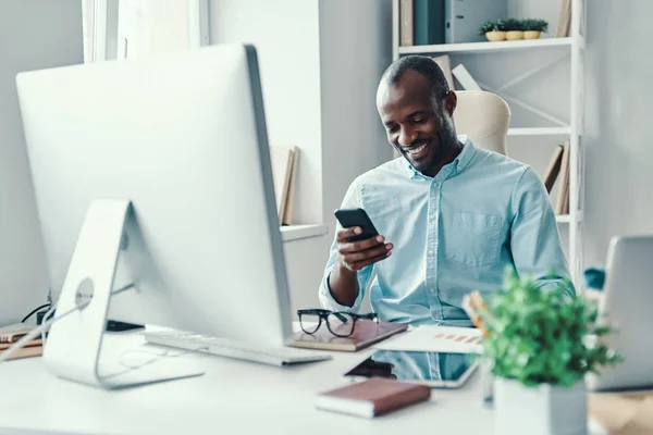 Feliz Joven Africano Con Camisa Usando Smartphone Sonriendo Mientras Trabaja — Foto de Stock