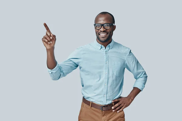 Charmanter Junger Afrikanischer Mann Zeigt Auf Kopierraum Und Lächelt Während — Stockfoto
