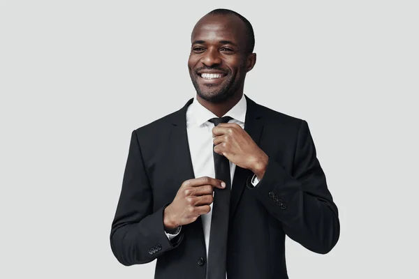 Elegant Young African Man Formal Wear Adjusting Tie Smiling While — Stock Photo, Image