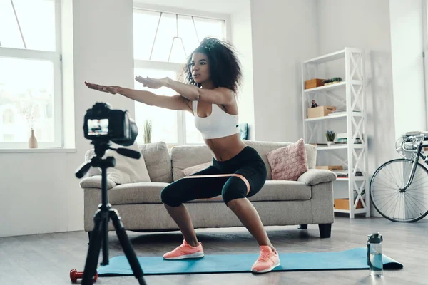 Hermosa Joven Africana Agachándose Usando Correa Mientras Hace Video Las — Foto de Stock