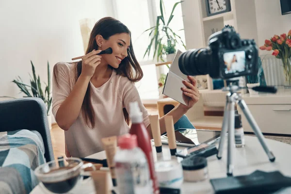 Linda Mujer Joven Aplicando Maquillaje Cepillo Sonriendo Mientras Hace Video —  Fotos de Stock