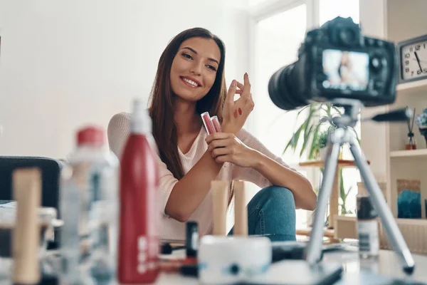 ソーシャルメディアビデオを作りながら唇の輝きと笑顔を適用する見事な若い女性 — ストック写真
