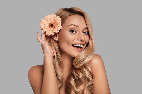 Mulher Bonita Ajustando Flor Seu Cabelo Sorrindo Enquanto Estava Contra — Fotografia de Stock