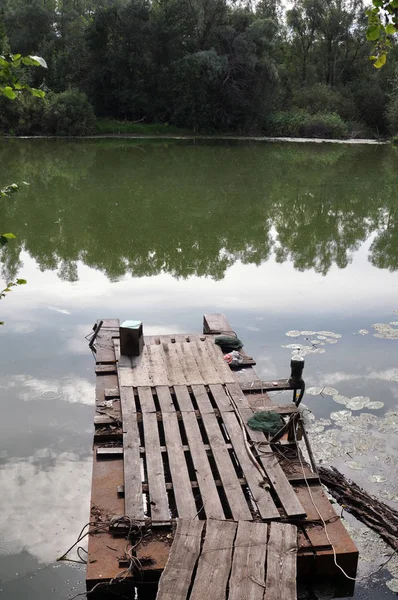 Sessiz bir gölün üzerindeki tahta köprü.