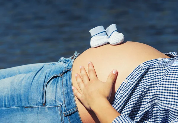 Meias de bebê na barriga da mãe — Fotografia de Stock