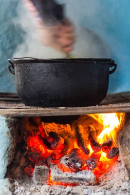Yemek tavada hazırlanırken, odunları da ısıtıyorlar.
