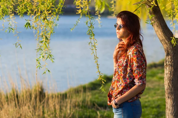 遠くに湖の近くに立って見て赤い髪の女性の側の写真 — ストック写真