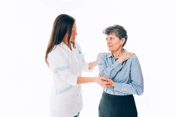 高齢女性の肩を調べる医師のポーズ 白に隔離 — ストック写真
