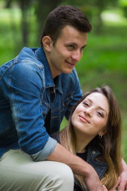 Erkek arkadaşı başka tarafa bakarken kameraya gülümseyen genç bir kadın. 