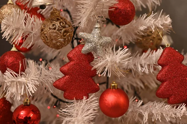 Beyaz Noel ağacı, kırmızı süslemeli ve noel ışığıyla