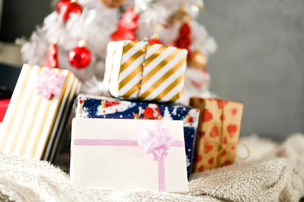 Beyaz Noel ağacı, kırmızı süslemeli ve noel ışığıyla