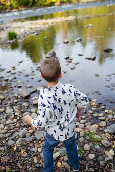 Geschwister werfen gemeinsam Steine in Fluss — Stockfoto