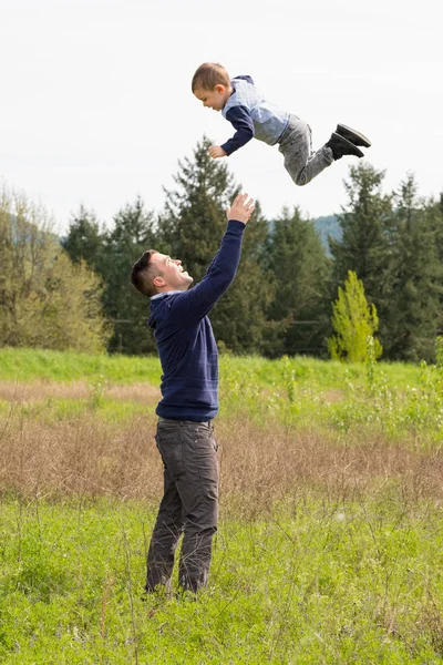Père jetant son fils dans l'air — Photo