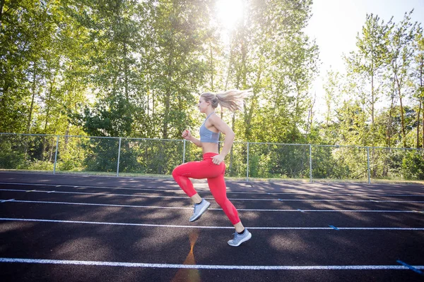 Giovane atleta donna che si allena in pista — Foto Stock