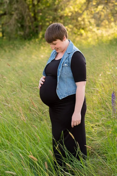 Mujer embarazada en un campo para las fotos de maternidad — Foto de Stock
