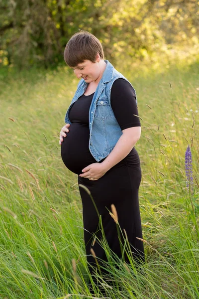 Mujer embarazada en un campo para las fotos de maternidad — Foto de Stock