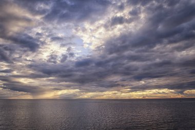 Güneş ışınları bulutların arasından Denizi üzerinden kırma