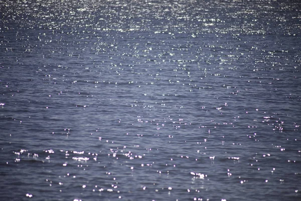 Ondulaciones de agua con reflejos del sol — Foto de Stock