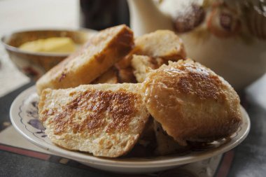 Ev yapımı kahvaltı. Tatlı ekmek bir çaydanlık, reçel arka plan üzerinde bir masaya bir tabak içinde kızarmış. Yakın çekim