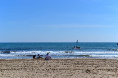 Çocuklar deniz kenarında kumsalda oynuyorlar.