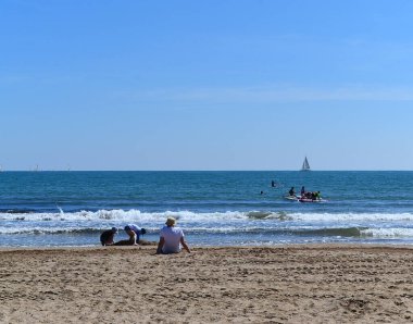 Çocuklar deniz kenarında kumsalda oynuyorlar.