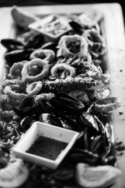 Limon ve fesleğen soslu kızarmış deniz ürünlerinin lezzetli bir karışımı.