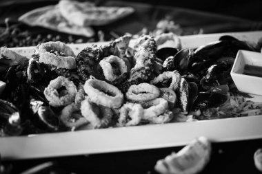 Limon ve fesleğen soslu kızarmış deniz ürünlerinin lezzetli bir karışımı.