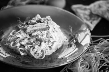 Lezzetli carbonara makarnası, taze malzemeler ve kızarmış pastırma.