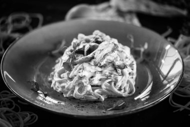 Lezzetli carbonara makarnası, taze malzemeler ve kızarmış pastırma.