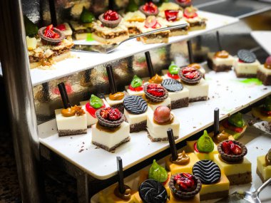 Mini kekleri taze meyvelerle karıştır ve üzerine de krem sür.