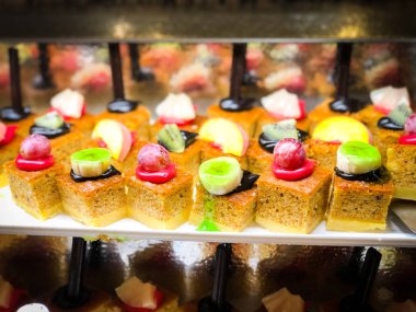 Mini kekleri taze meyvelerle karıştır ve üzerine de krem sür.