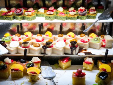 Mini kekleri taze meyvelerle karıştır ve üzerine de krem sür.