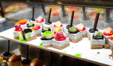 Mini kekleri taze meyvelerle karıştır ve üzerine de krem sür.