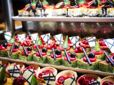 Mini kekleri taze meyvelerle karıştır ve üzerine de krem sür.