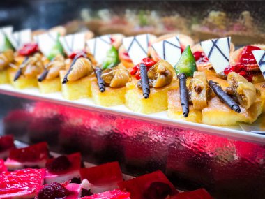 Mini kekleri taze meyvelerle karıştır ve üzerine de krem sür.