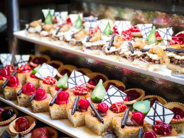 Mini kekleri taze meyvelerle karıştır ve üzerine de krem sür.