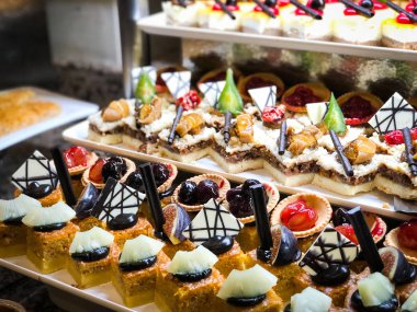 Mini kekleri taze meyvelerle karıştır ve üzerine de krem sür.