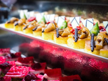 Mini kekleri taze meyvelerle karıştır ve üzerine de krem sür.