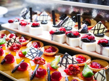 Mini kekleri taze meyvelerle karıştır ve üzerine de krem sür.