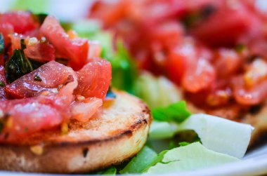 Sarımsaklı taze domates bruschetta, zeytinyağı ve fesleğen.