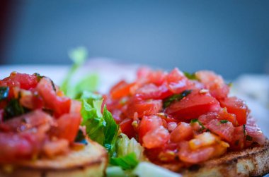 Sarımsaklı taze domates bruschetta, zeytinyağı ve fesleğen.